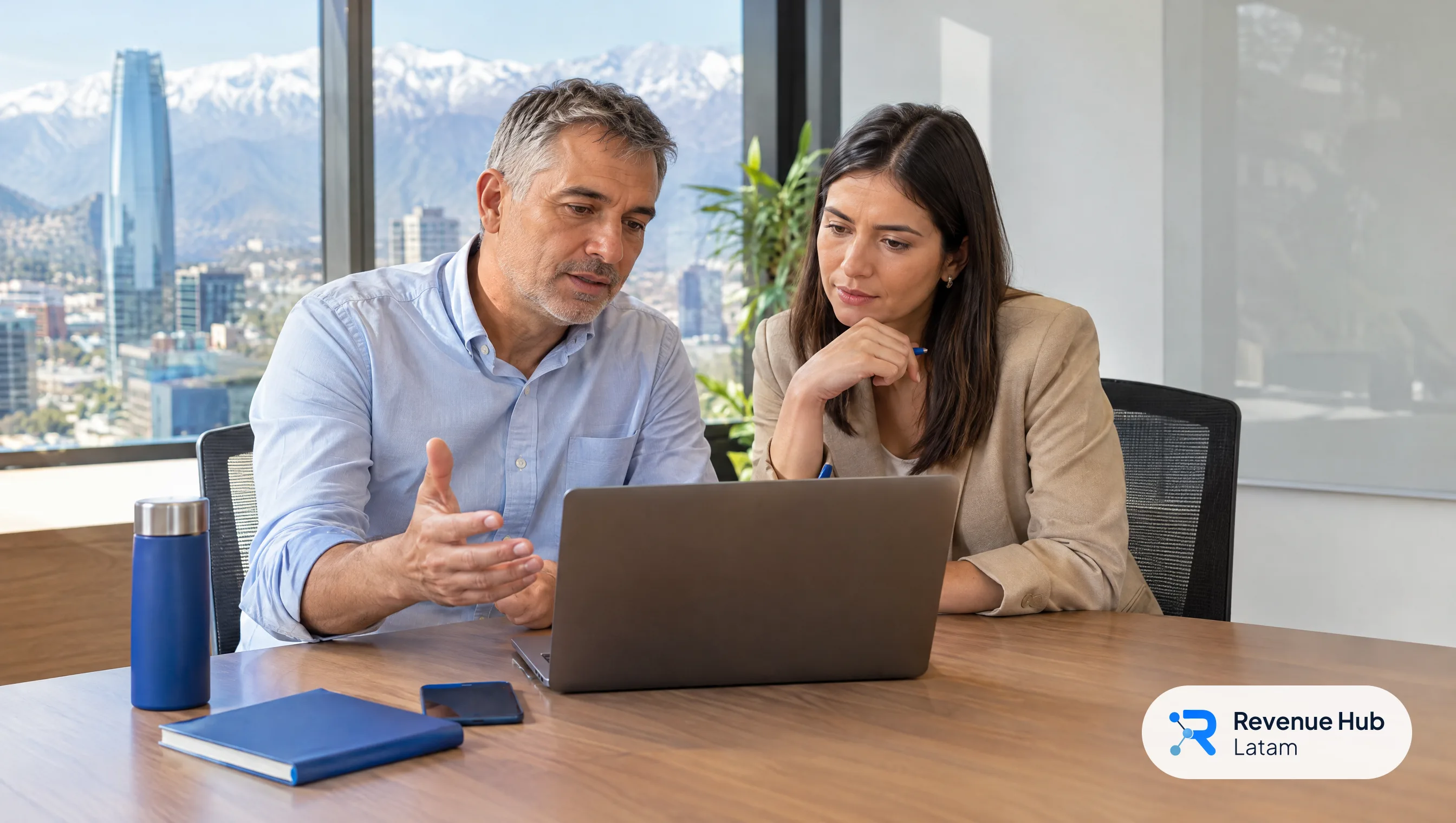 Gerente comercial y vendedora preparan juntos una reunión de venta frente a un notebook en una oficina de Santiago